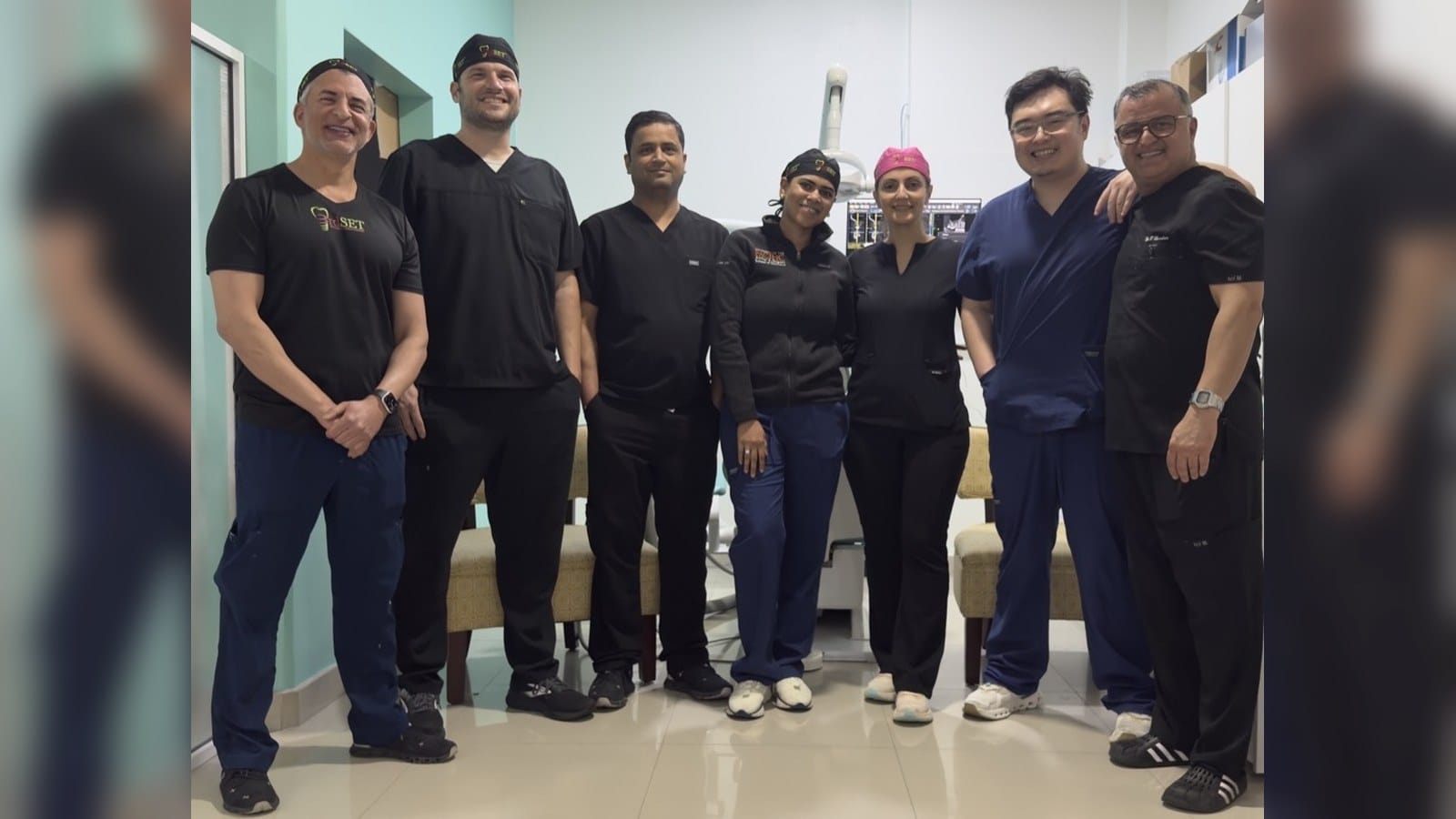 Past course participants and instructors standing together between sessions