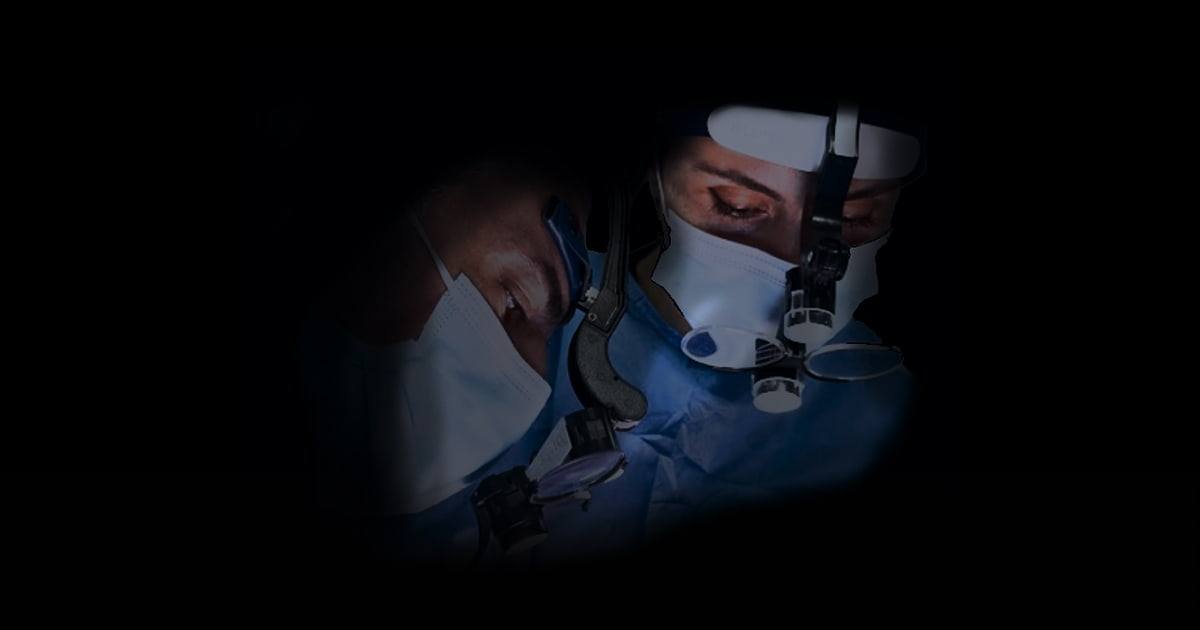 Clinicians performing live dental implant surgery